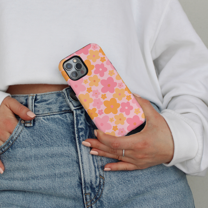 Person holding a Coconut Lane Tough Phone Case in pink and orange with a bold floral pattern.