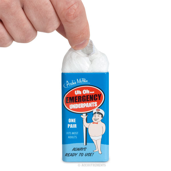 A hand pulls out white, disposable unisex underpants from a blue "Uh Oh... Emergency Underpants" tin featuring a cartoon character.