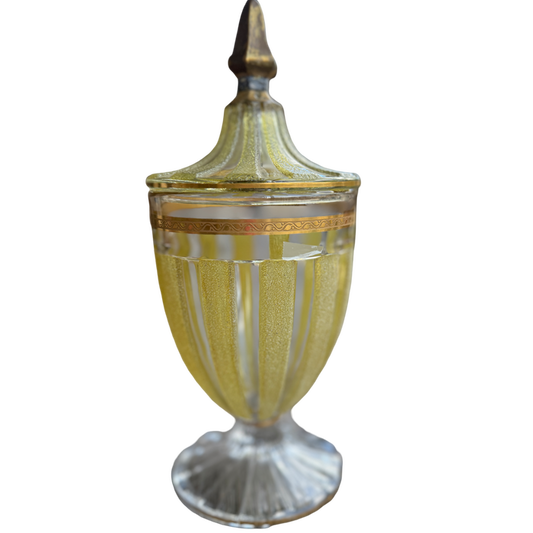 Decorative glass urn with gold accents on a white background