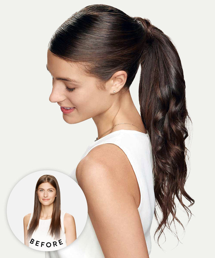 A woman with long, dark, wavy hair in a voluminous ponytail smiles down; inset shows her earlier straight hair, highlighting the change with Perfect Locks Wavy Clip-In Ponytail Extensions in Natural Black .