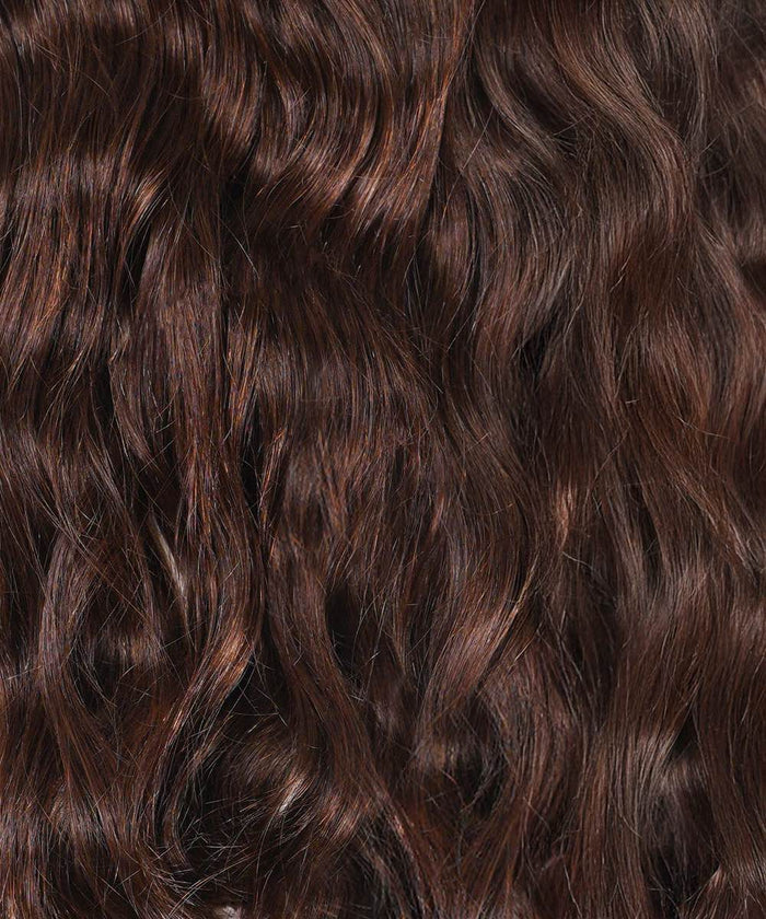 Close-up of long, wavy, golden brown hair with shiny highlights, showing texture and natural wave pattern of Perfect Locks Wavy Clip-In Ponytail Extensions in Color 6.#color_chocolate-brown-(3)