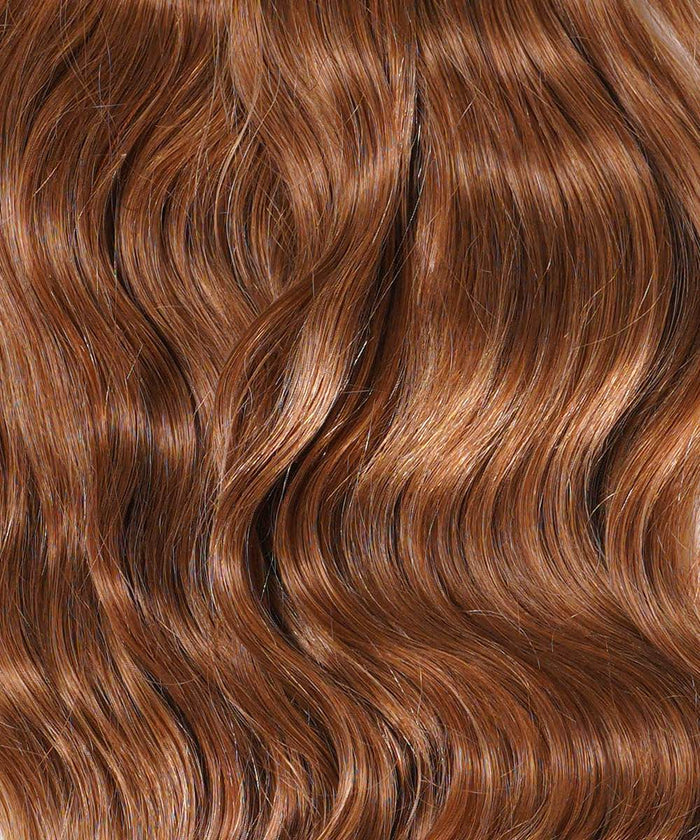 Close-up of long, wavy, shiny honey blonde hair with Perfect Locks Wavy Clip-In Ponytail Extensions (Color: 27), smooth and vibrant.#color_golden-brown-(6)