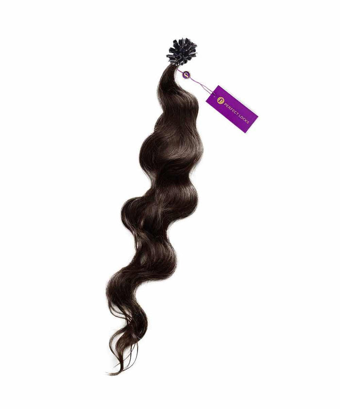 A bundle of dark brown, wavy hair extensions with a soft texture and a purple tag near the top, isolated on white.