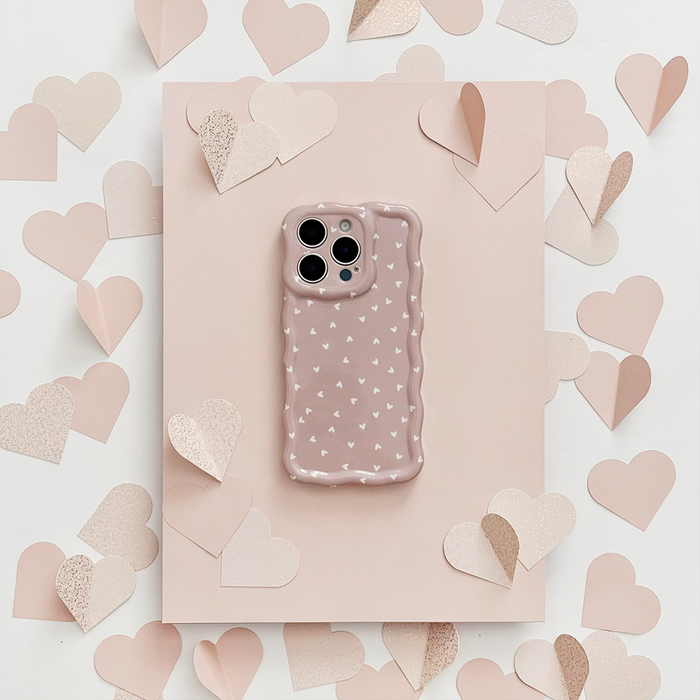 Mauve phone in Coconut Lane Wavy Phone Case with chai heart pattern, on pink paper with pink paper hearts.