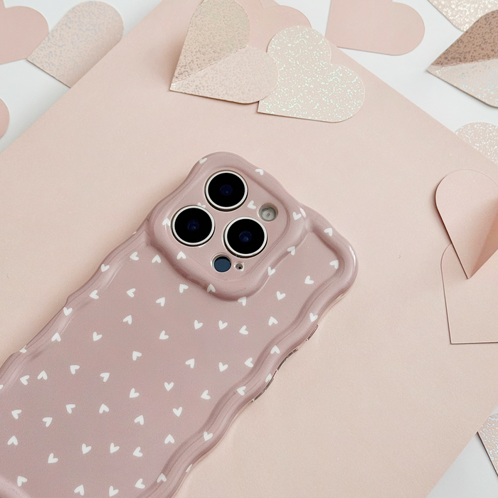 Pink wavy phone case with heart pattern, shown on a pink background with paper hearts.
