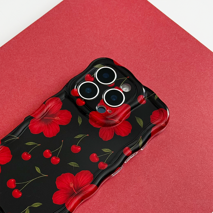 Red phone case with wavy edges featuring red flowers and cherry illustrations on a bold red background.