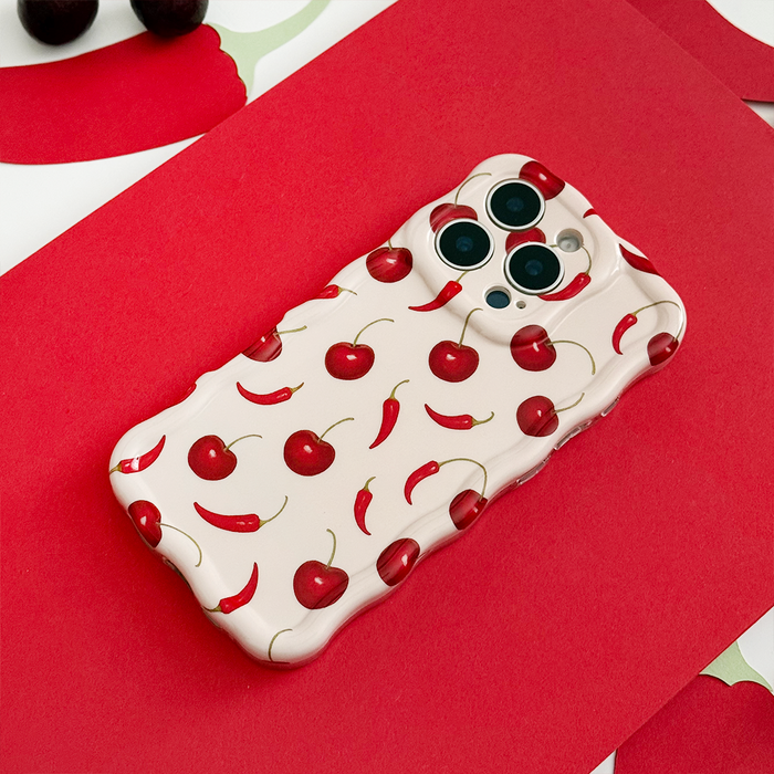 Cream wavy phone case with red cherry and chili pepper motifs, featuring raised curvy edges.