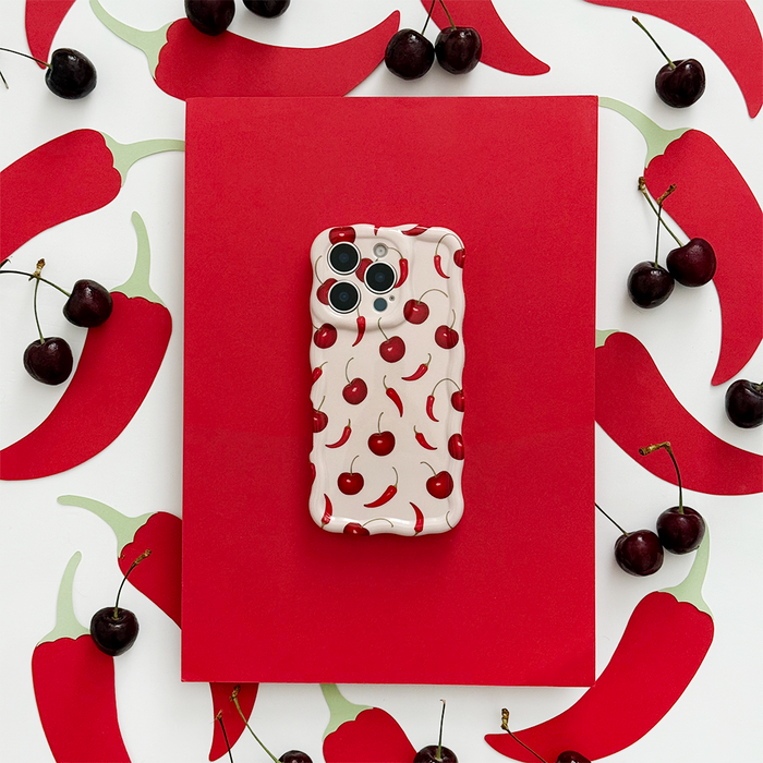 Coconut Lane wavy phone case with a cherry and chili pattern on a red background.