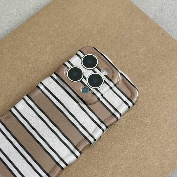 Coconut Lane wavy phone case with retro stripes on a smartphone with triple cameras, shown on a brown surface.