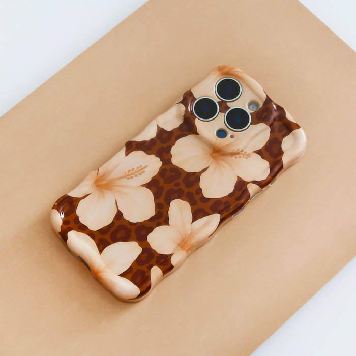 Brown phone case with wavy floral and leopard print design on a light brown surface.
