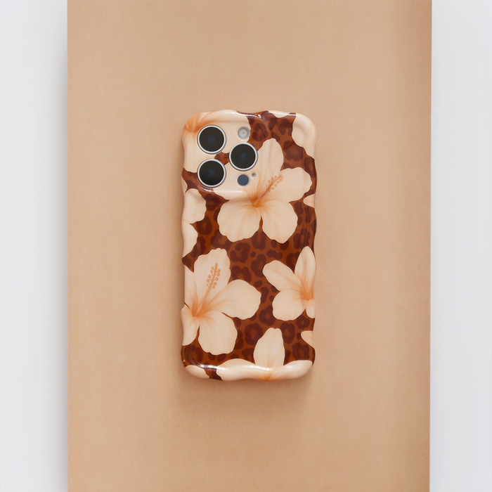 IPhone with a beige Wavy Phone Case featuring light peach hibiscus flowers, by Coconut Lane.